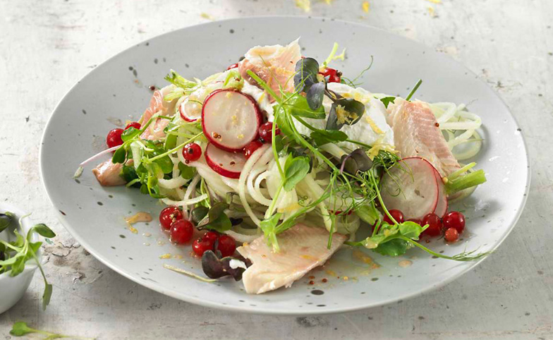 Cette salade de truite regorge de superaliments: chou-rave, petits radis, groseilles rouges, micro-greens et naturellement des filets de truite.