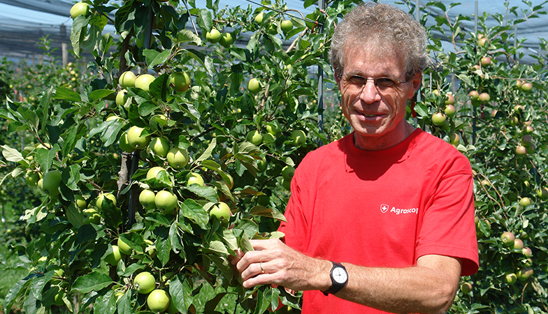 Markus Kellerhals avec «ses» pommes dans le verger de la station Agroscope.