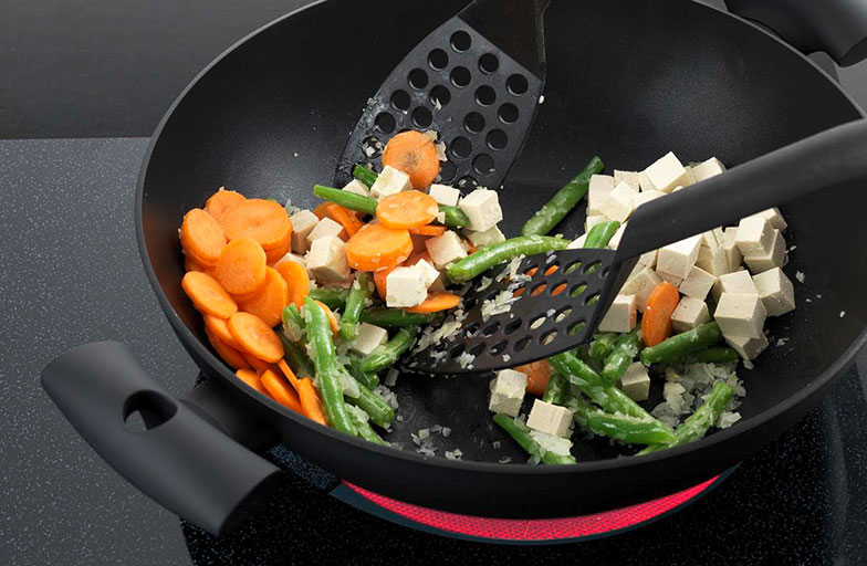 Pour garder les ingrédients au chaud, on les pousse sur le bord incliné du wok.