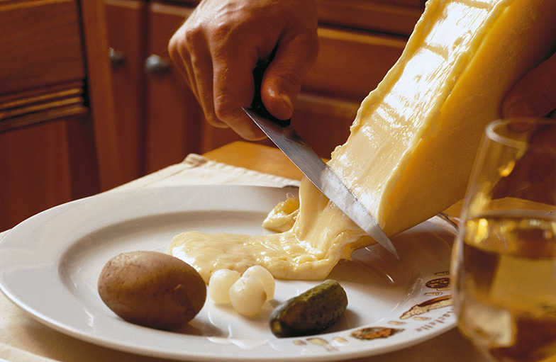 À l’origine, le fromage est fondu directement sur la meule et raclé au fur et à mesure sur l’assiette.